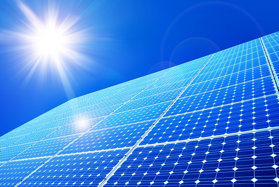 Solar panels installed in a rural Kenyan landscape with a telecommunications tower in the background